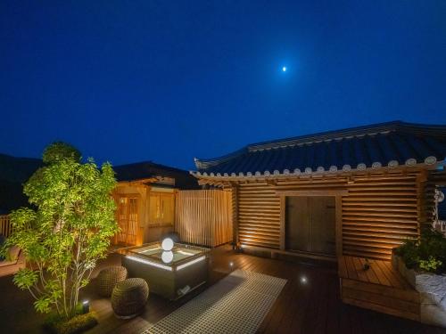 a house with a deck at night with the moon at Hotel New Wakasa in Nara