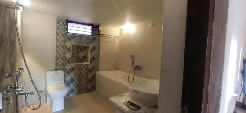 a bathroom with a tub and a toilet and a sink at Estancia Tranquila's Casa de la Abuela in Puducherry