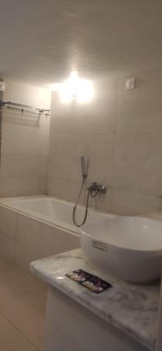 a white bathroom with a tub and a sink at Estancia Tranquila's Casa de la Abuela in Puducherry
