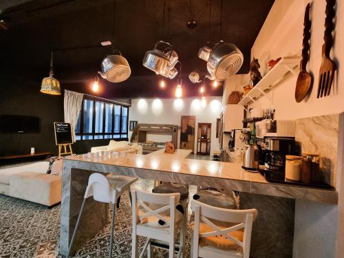 a kitchen and living room with a large counter and chairs at Clocktower Homestay 2 to 8 pax at Brinchang, Cameron Highlands in Cameron Highlands