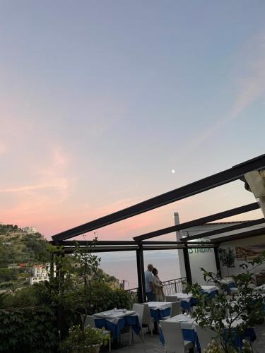 a restaurant with tables and chairs on a balcony at Fico D'India Relais in Furore