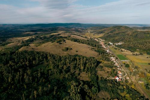 an aerial view of a forested hill with a town at Vidéki vendégház a Bükkben, pezsgőfürdővel. in Királd