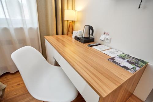 a desk in a hotel room with a white chair at Hotel Garden Court in Prague