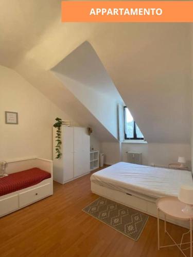 a white bedroom with a bed and a window at MansardaTO - La Tua casa nel cuore di Torino in Turin