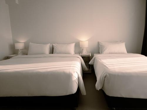 two beds sitting next to each other in a room at POR Santitham in Chiang Mai
