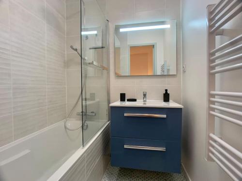 een badkamer met een blauwe wastafel en een douche bij La Verrière Saint-Martin - Historic Center & WIFI in Bayeux