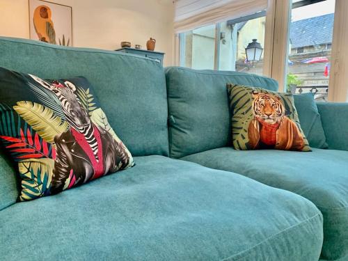 - un canapé bleu avec deux oreillers dans l'établissement La Verrière Saint-Martin - Historic Center & WIFI, à Bayeux