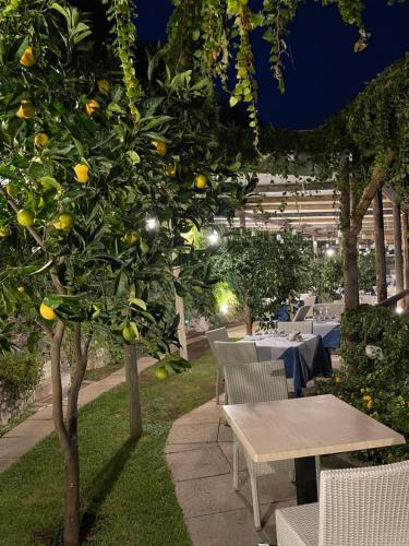 an outdoor dining area with a lemon tree and tables at Fico D'India Relais in Furore