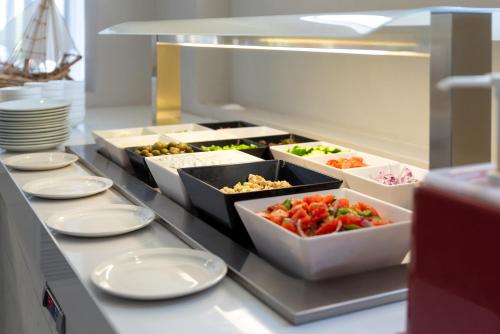 a buffet line with dishes of food on a counter at Afandou Blu in Afantou