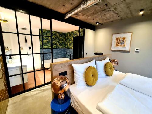 a bedroom with a bed with white sheets and yellow pillows at KONCEPT HOTEL International in Cologne