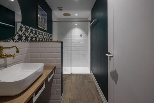 ein Badezimmer mit einem weißen Waschbecken und einer Dusche in der Unterkunft Wello Apartments Sevilla in Sevilla