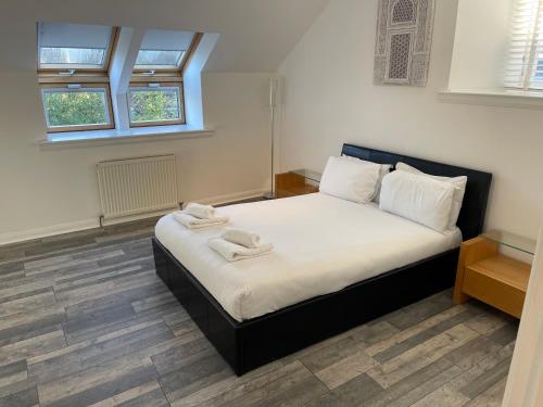 a bedroom with a bed with two towels on it at Abbey House in Paisley