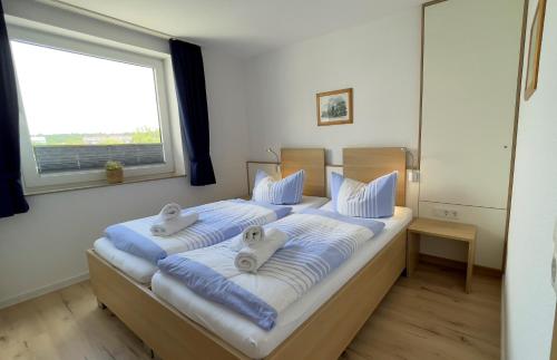 a bedroom with two beds with towels on them at Haus Horizont Fewo Nr. 4 in Cuxhaven