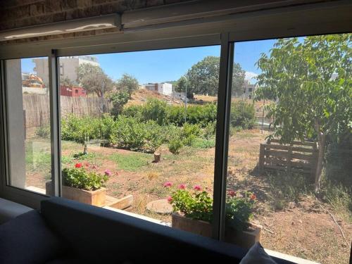 a view of a garden from a window at Al baidar zimmer in Mas'ade