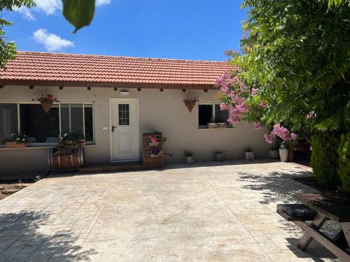 a white house with a patio and a driveway at Al baidar zimmer in Mas'ade
