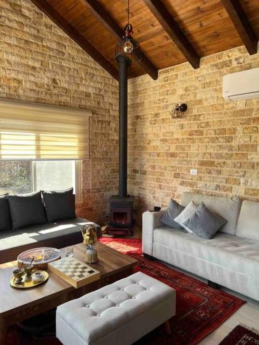 a living room with two couches and a fireplace at Al baidar zimmer in Mas'ade