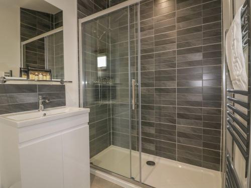 a bathroom with a glass shower and a sink at 18 Meadow Retreat in Liskeard