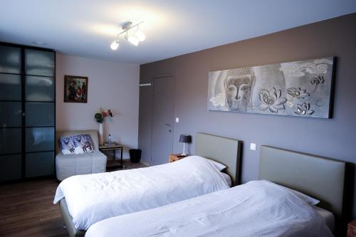ヘントにあるBed and breakfast Mentariのベッドルーム1室(ベッド2台付)が備わります。壁には絵画が飾られています。