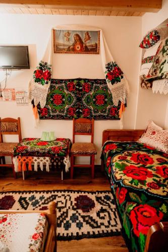 a living room with a couch and a bed and chairs at Casa Pintea de Sub Coastă in Breb
