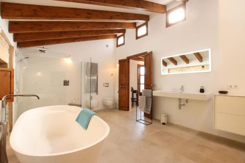 a large bathroom with a tub and a sink at Can Xiprers in Pollença