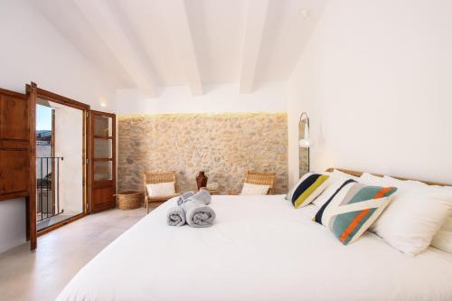 a bedroom with a large white bed and a window at Can Xiprers in Pollença