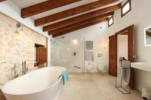 a bathroom with a large tub and two toilets at Can Xiprers in Pollença