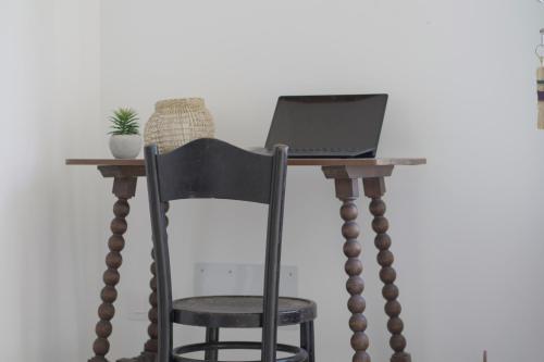 a desk with a chair and a laptop on it at Can Xiprers in Pollença