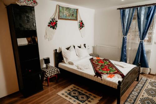 a bedroom with a bed and a window at Casa Pintea de Sub Coastă in Breb