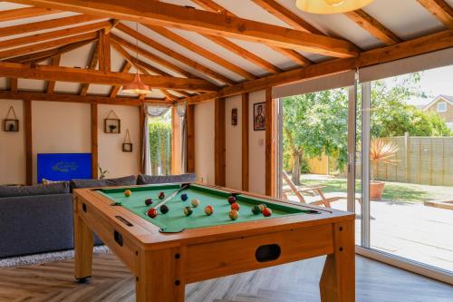 a pool table in a living room with a pool at The Cabin in Fareham