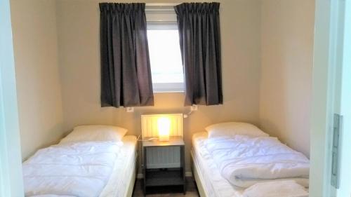 2 Betten in einem Zimmer mit Fenster in der Unterkunft Luxe cottage met fietsen, airco & infrarood cabine in Knokke-Heist