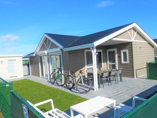 a small house with bikes parked on a deck at Luxe cottage met fietsen, airco & infrarood cabine in Knokke-Heist