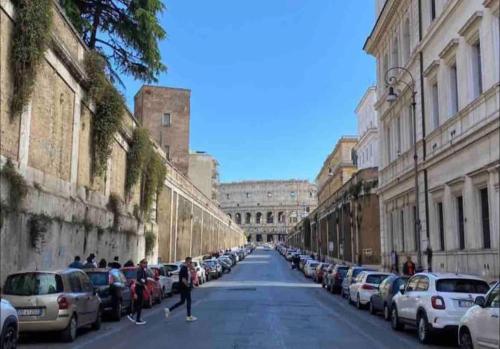 a street with cars parked on the sides of the road at Colosseum Charming Stay in Rome