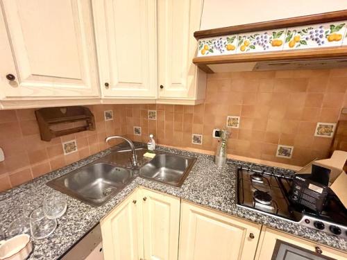 a kitchen counter with a sink and a stove at Colosseum Charming Stay in Rome