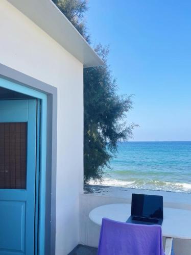 a laptop sitting on a table next to the ocean at Paradise on Kantouni Beach-20m from Boutique Hotel in Kalymnos