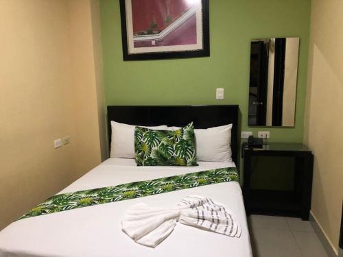 Un dormitorio con una cama con una pajarita. en Ayenda Hotel Ecosuite Quibdó en Quibdó