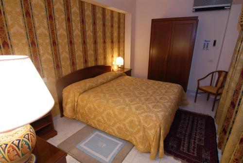 a hotel room with a bed and a lamp at Hotel Il Mulino in Capo dʼOrlando
