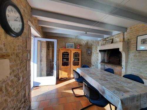 une chambre avec une table et une horloge sur le mur dans l'établissement Domaine de Fontsauzine - gîtes et chambre d'hôtes, à Genouillé