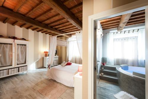 a bathroom with a bed and a tub in a room at Agriturismo Belagaggio in Montefollonico