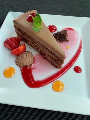 a piece of cake on a white plate with strawberries at All Seasons Residence Design Hotel - Free parking in Sofia