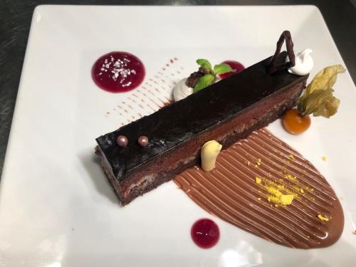 a piece of chocolate dessert on a white plate at All Seasons Residence Design Hotel - Free parking in Sofia