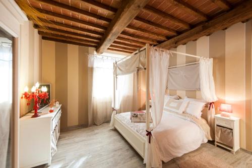 a bedroom with a canopy bed and a wooden ceiling at Agriturismo Belagaggio in Montefollonico