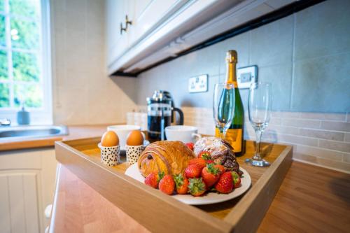 a table with a plate of food and strawberries on it at Beautiful detached home in quaint village setting in Wetherby