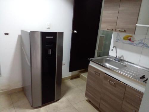 a kitchen with a stainless steel refrigerator and a sink at montecarlos hotel in Ibagué