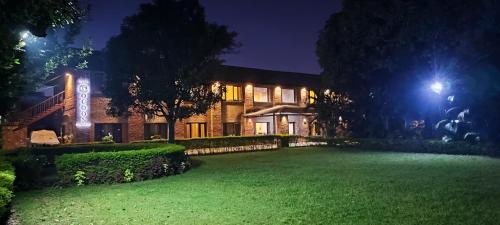 a house with a lawn in front of it at night at The Cocoon in Dehradun