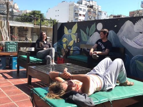 a woman laying on a bed on a patio at Reina Madre Hostel in Buenos Aires