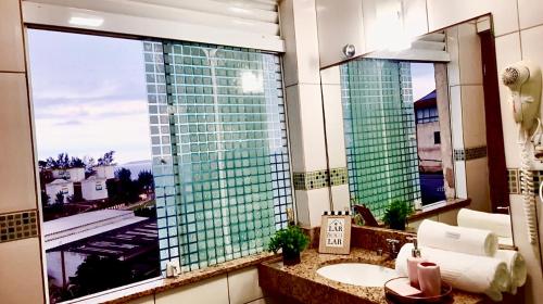 a bathroom with a sink and a large window at Flat bela vista master in Macaé