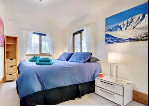 a bedroom with a bed with blue sheets and mountains at Mountain View Cottage, Hot Tub , Stunning Views in Llanhamlach