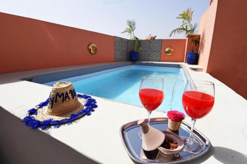 a table with two glasses of wine and a tray of food at Riad CK Medina in Marrakech
