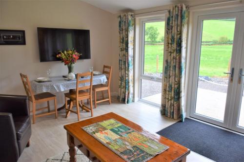 uma sala de estar com uma mesa e uma sala de jantar em Alderneuk Lodge em Dumfries