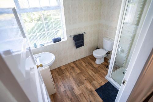a bathroom with a toilet and a sink and a shower at Beautiful detached home in quaint village setting in Wetherby